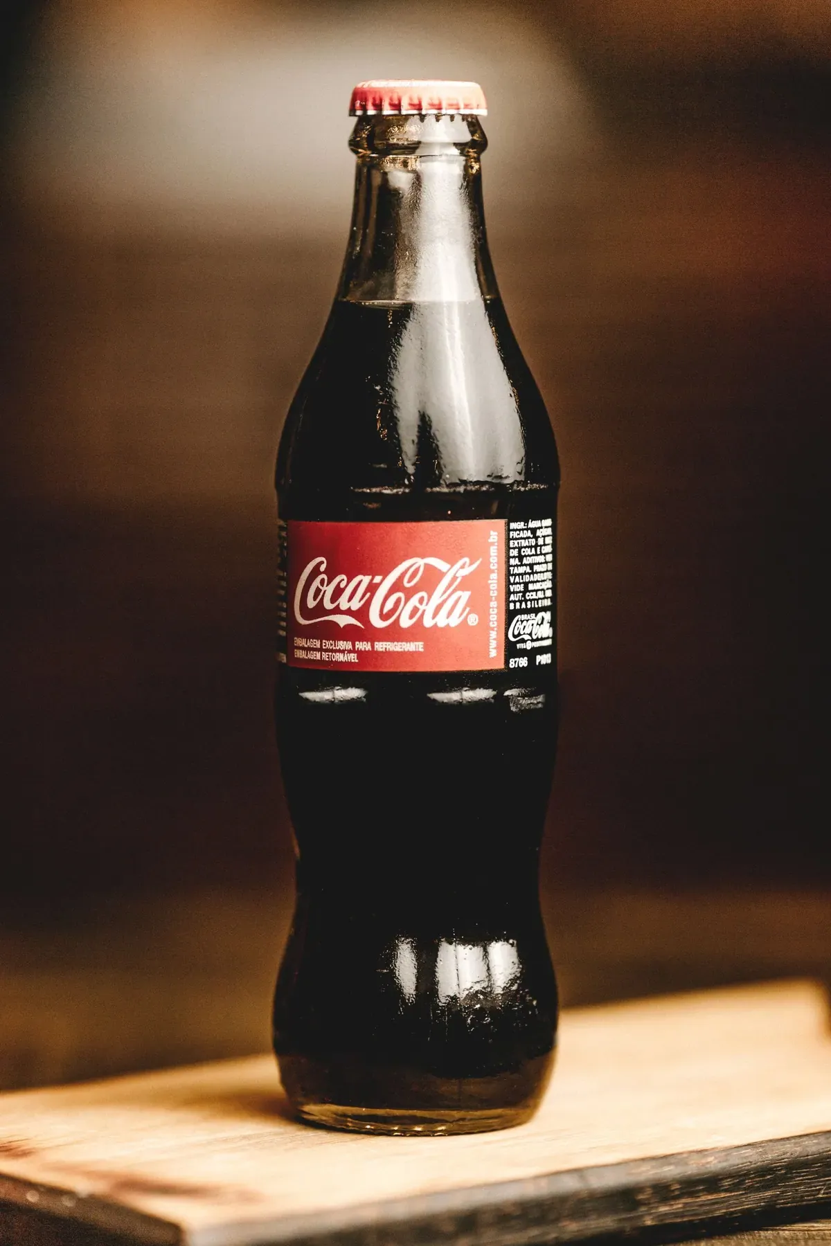 Botella de cristal de refresco sobre mesa de madera