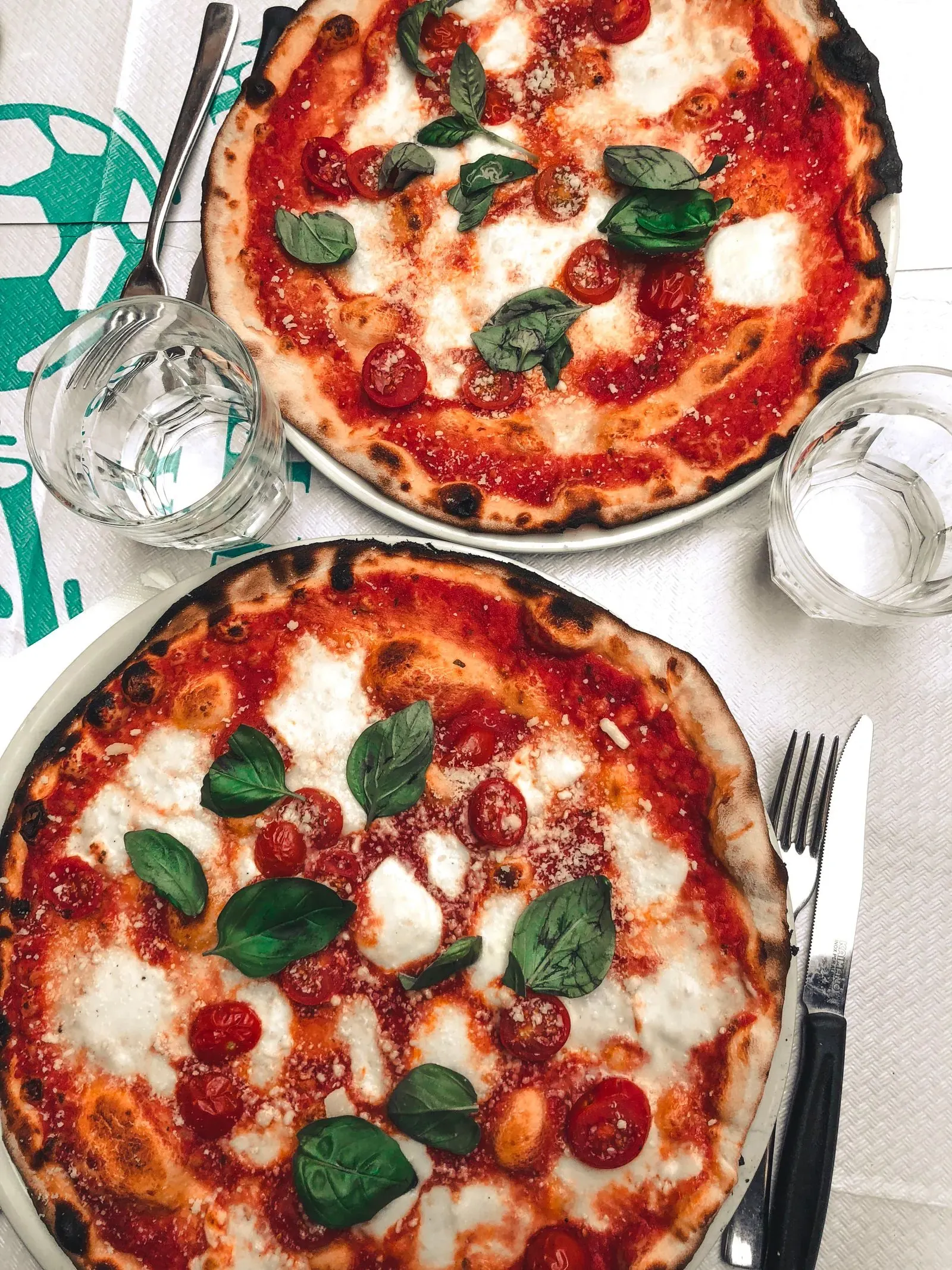 Dos pizzas margherita en mantel blanco